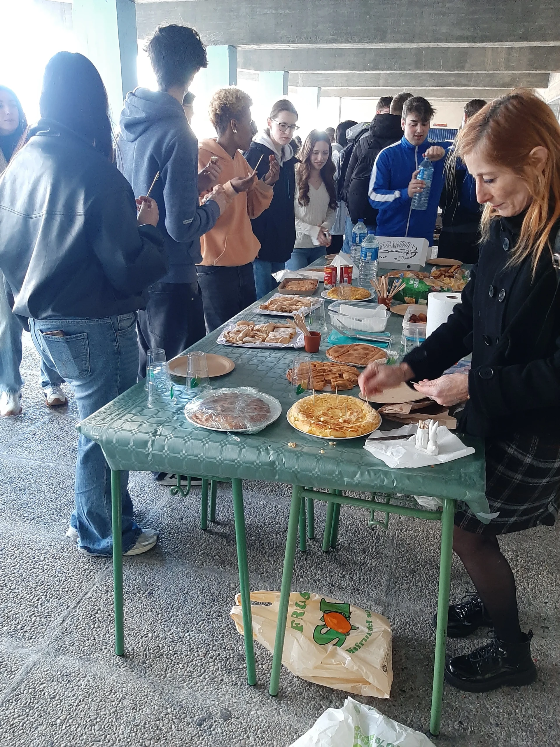 Schülergruppe um Tisch mit verschiedenen selbstgemachten Tapas